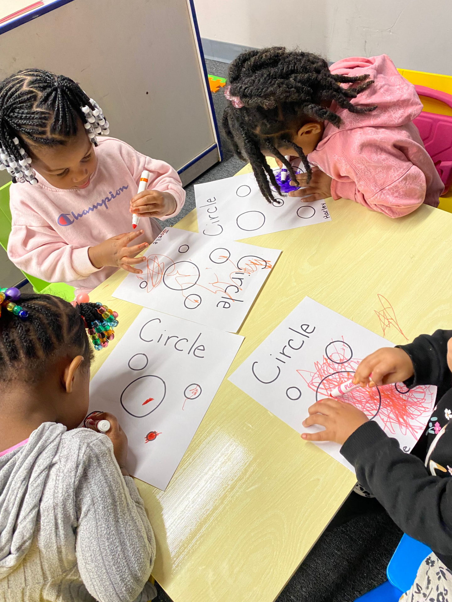 Children working together on shape-tracing activities in the classroom